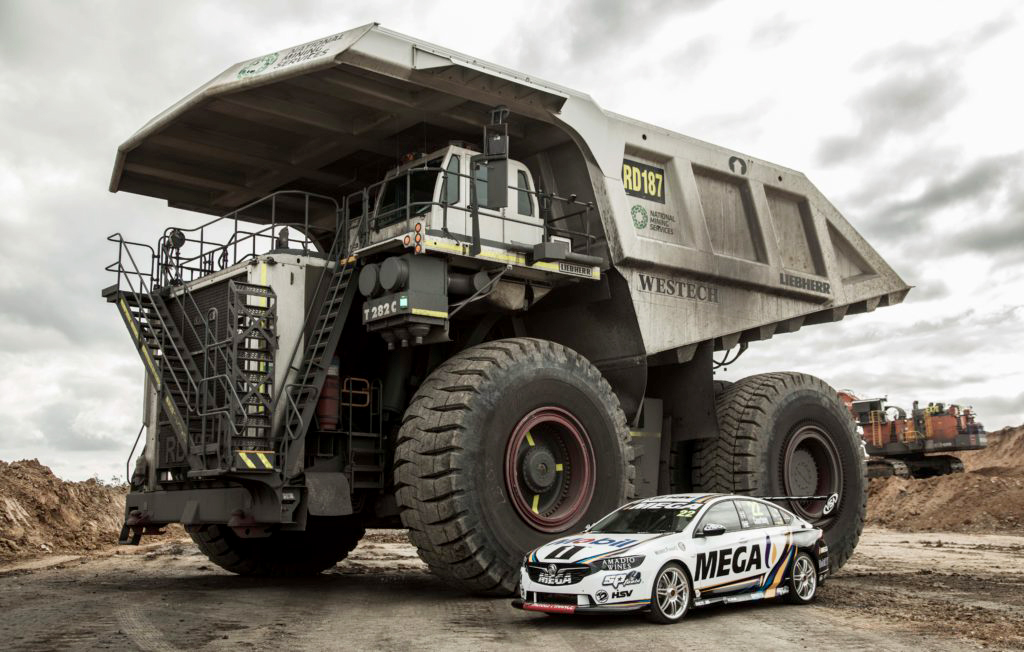 Supercar next to Liebherr T282C Mining Dump Truck